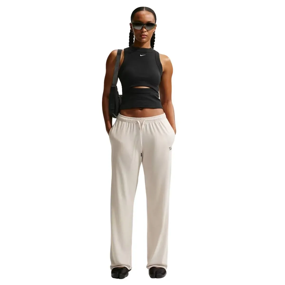 Mulher usando calça casual feminina Nike Chill Knit cinza, vista frontal com logotipo visível
